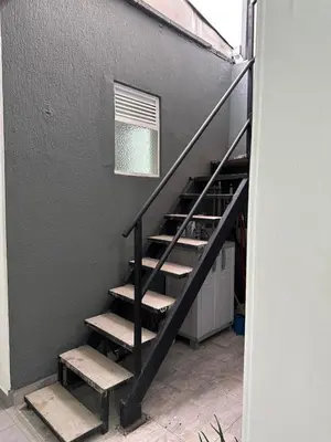 a black staircase with steps next to a wall with a window at Aparta estudio amoblado Medellin, San joaquin in Medellín
