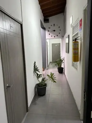 an empty hallway with potted plants in a building at Aparta estudio amoblado Medellin, San joaquin in Medellín