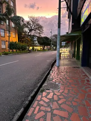 an empty street with a brick sidewalk next to a building at Aparta estudio amoblado Medellin, San joaquin in Medellín