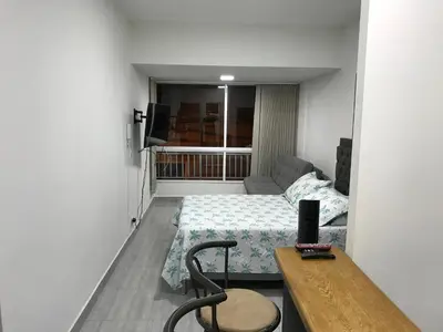 a small room with a bed and a table in it at Aparta estudio amoblado Medellin, San joaquin in Medellín