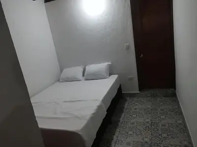 a small white bed in a small room at dulce estancia in Jardin