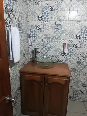 a bathroom with a sink and a tile wall at dulce estancia in Jardin