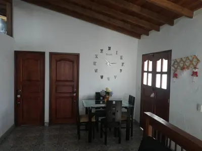 a dining room with a table and a clock on the wall at dulce estancia in Jardin