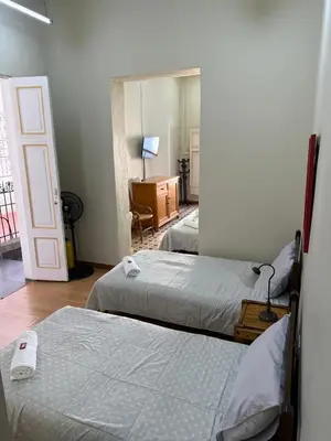 a room with two beds and a room with a desk at Del Rocío Alojamiento -ANDES in Los Andes