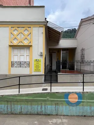 a white and yellow house with a fence at Del Rocío Alojamiento -ANDES in Los Andes