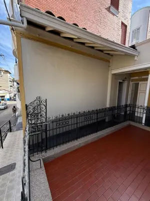 a garage with a fence next to a building at Del Rocío Alojamiento -ANDES in Los Andes