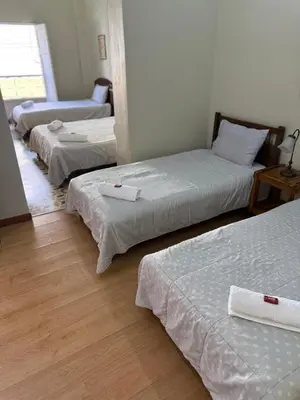 a group of three beds in a room at Del Rocío Alojamiento -ANDES in Los Andes