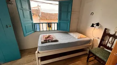 a small bed in a room with a window at Parcerito's Hostel in Jericó