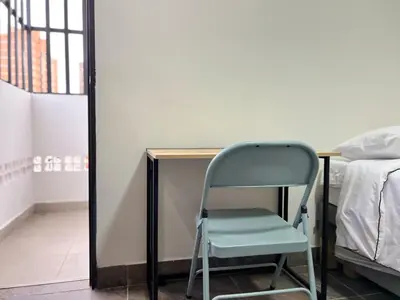 a chair sitting next to a desk in a room at Casa hotel Los Laureles in Medellín