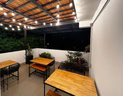 two tables and chairs on a patio with lights at Casa hotel Los Laureles in Medellín