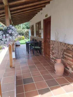 a patio with a wooden door and a table at Samaria, un lugar para descansar y disfrutar in Santa Elena