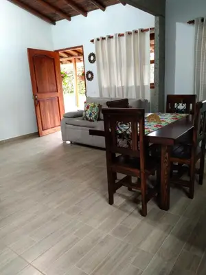 a dining room with a table and chairs and a couch at Samaria, un lugar para descansar y disfrutar in Santa Elena