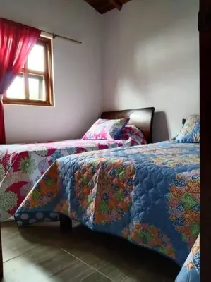 a bedroom with two beds and a window at Samaria, un lugar para descansar y disfrutar in Santa Elena