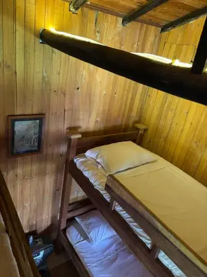 two bunk beds in a room with wooden walls at BioHotel Ecohouse in Guarne