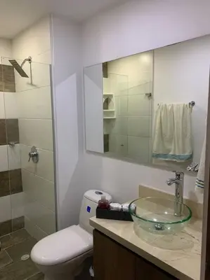 a bathroom with a sink and a toilet and a mirror at Piso13 Sabaneta, apartment, Parking, Pool & with club in the sky! in Sabaneta