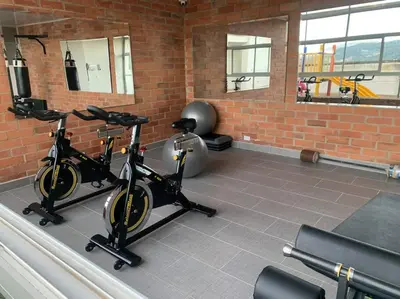 a gym with two exercise bikes in a brick wall at Piso13 Sabaneta, apartment, Parking, Pool & with club in the sky! in Sabaneta