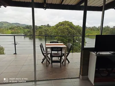 a table and chairs on a balcony with a view of a lake at El Espume de San Juan by JR in Guatapé