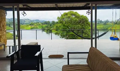 a living room with a view of the water at El Espume de San Juan by JR in Guatapé