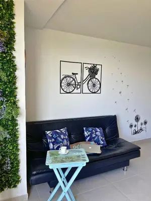 a living room with a black couch with a bike on the wall at Apartamentos Avenida del malecón, frente al lago. Guatape in Guatapé