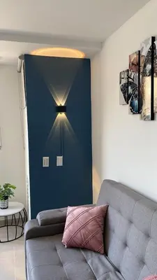 a living room with a couch and a blue wall at Apartamentos Avenida del malecón, frente al lago. Guatape in Guatapé