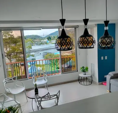 a living room with a table and chairs and windows at Apartamentos Avenida del malecón, frente al lago. Guatape in Guatapé