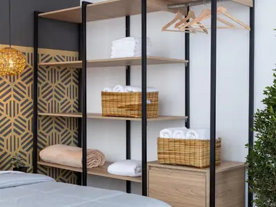 a bedroom with a black and wood shelving unit with baskets at Lexum by Bernalo Hotels in Medellín