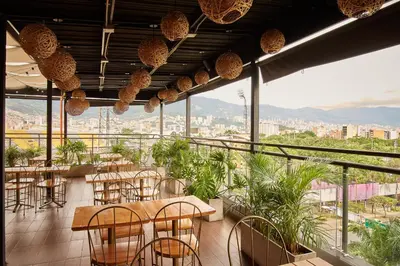 a restaurant with tables and chairs and a view of a city at Lexum by Bernalo Hotels in Medellín