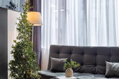 a living room with a couch and a christmas tree at Lexum by Bernalo Hotels in Medellín