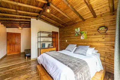 a bedroom with a bed in a room with wooden walls at Cerro Verde Mirador in Medellín
