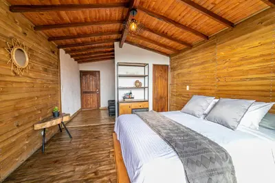 a bedroom with a bed in a wooden wall at Cerro Verde Mirador in Medellín
