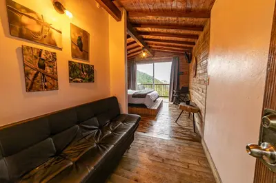 a living room with a leather couch and a bedroom at Cerro Verde Mirador in Medellín