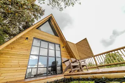 a log cabin with a large window on a deck at Cerro Verde Mirador in Medellín