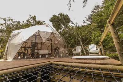 a tent on a deck with two chairs and a table at Cerro Verde Mirador in Medellín