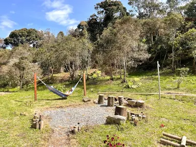 a person swinging in a hammock in a field at BRUMA BLANCA CHALETS in Medellín