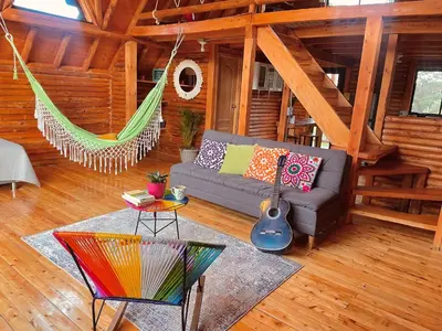 a living room with a couch and a hammock at BRUMA BLANCA CHALETS in Medellín