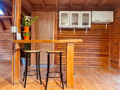 a wooden bar in a room with two stools at BRUMA BLANCA CHALETS in Medellín
