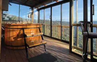a wooden balcony with a wooden bench on a deck at Skyline Ecoliving Santa Elena in Santa Elena