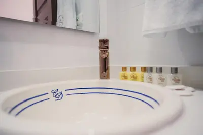a bathroom with a white sink with blue lines on it at Hotel Boutique La Leyenda 1860 in Salamina