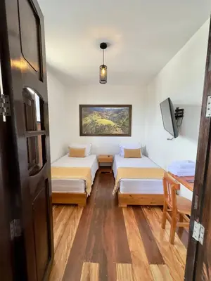 a room with two beds and a table in it at Hotel Boutique La Leyenda 1860 in Salamina