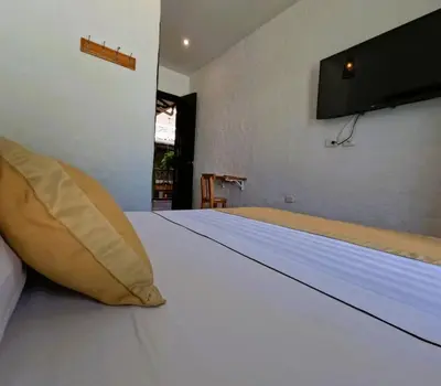 a large white bed with a yellow pillow on it at Hotel Boutique La Leyenda 1860 in Salamina