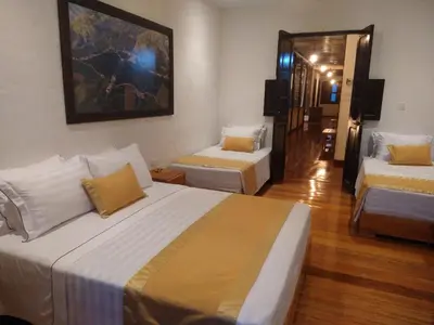 a hotel room with two beds and a television at Hotel Boutique La Leyenda 1860 in Salamina