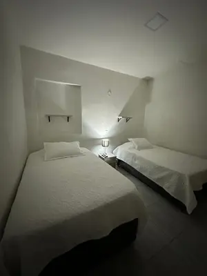 two beds in a small room with two lamps at Aparta estudio amoblado 2 Medellin, San joaquin in Medellín