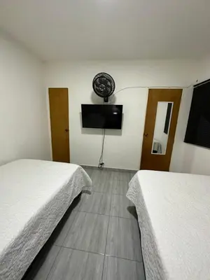 a room with two beds and a flat screen tv at Aparta estudio amoblado 2 Medellin, San joaquin in Medellín