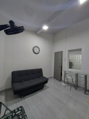 a living room with a black couch and a table at Aparta estudio amoblado 2 Medellin, San joaquin in Medellín