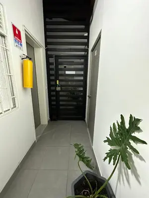 a hallway with a black door and some plants at Aparta estudio amoblado 3 Medellin, San joaquin in Medellín