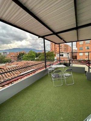 a table and chairs on a roof with train tracks at Aparta estudio amoblado 3 Medellin, San joaquin in Medellín