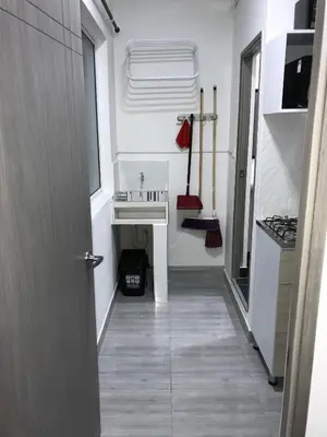a hallway leading to a kitchen with a sink at Aparta estudio amoblado 3 Medellin, San joaquin in Medellín