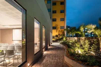 a corridor of a building with tables and chairs at Fairfield by Marriott Medellin Sabaneta in Medellín