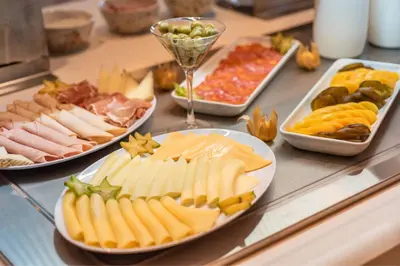 a buffet filled with different types of cheese and meats at Fairfield by Marriott Medellin Sabaneta in Medellín