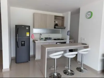 a kitchen with a refrigerator and two bar stools at Apartamento Citadela Di Sole Santa fe De Antioquia in Santa Fe de Antioquia